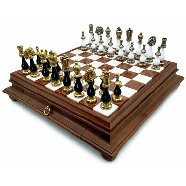 Two-tone black and white chess board with gold and silver metal pieces arranged