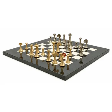 Solid brass pieces arranged on the board, reflection on the marble base