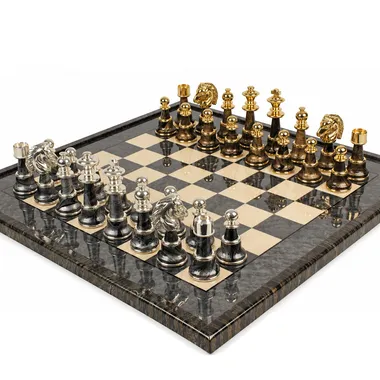Chess board and gold and silver brass pieces viewed at an angle