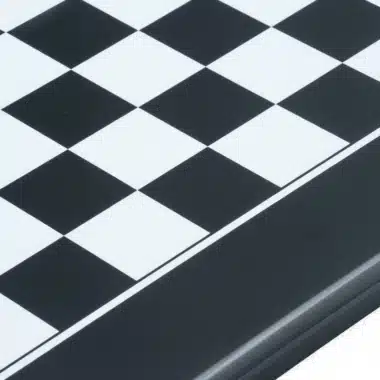 Close-up of the black lacquered edge and squares of the chess board