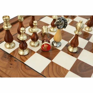 Close-up of wood and metal Staunton chess pieces on the board