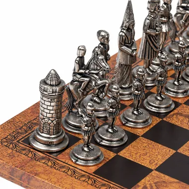 Close-up of the silver Camelot pieces, knights and rook on the faux leather chess board