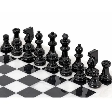 Black marble pieces lined up on the chess board, close-up view