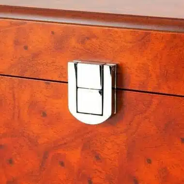 Chrome clasp close-up on the burr wood veneer of the closed box