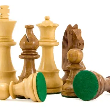 Staunton chess set pieces with two kings lying on green felt bases