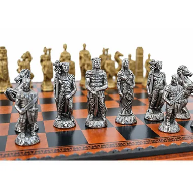 Gold and silver metal pieces lined up on the faux leather chess board