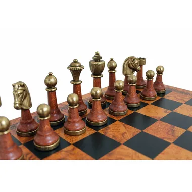 Staunton pieces in brown and gold wood on the board's black and gold squares