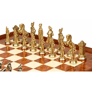 Gold-toned Napoleon chess pieces lined up on the elm wood chess board