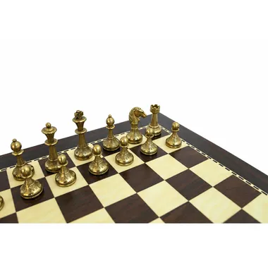 Gold pieces of the small metal chess set lined up on the board