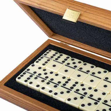 Close-up of the open box with dominoes and engraved gold plaque