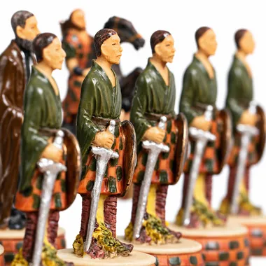Chess pieces in a row depicting Scottish warriors in kilts armed with swords