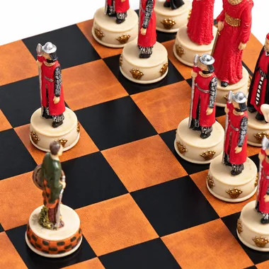 Red and ivory resin pieces lined up on the faux leather chess board