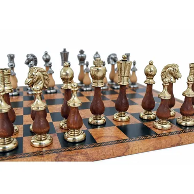 Arabesque wood and metal chess pieces lined up on the board