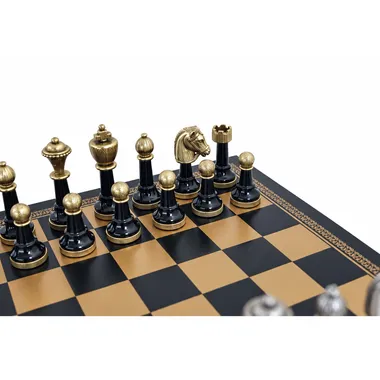 Close-up of black Staunton pieces lined up on the gold and black chessboard