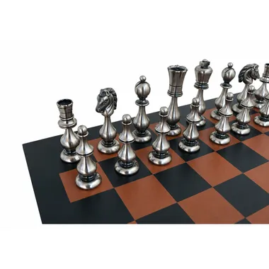 Silver-toned Grand Oriental chess pieces viewed diagonally on the leather board