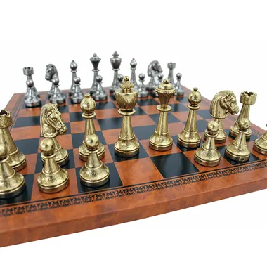 Gold and silver Staunton pieces lined up on the brown faux leather chess board