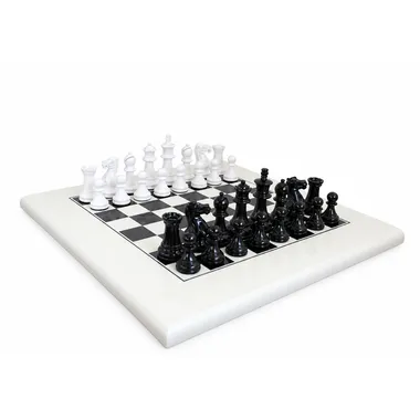 Staunton black and white chess set arranged on a white chess board