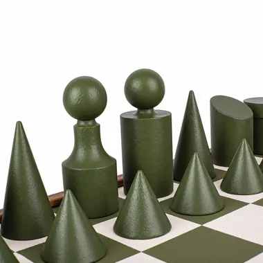 Green Bauhaus-style chess pieces with geometric shapes on the chess board
