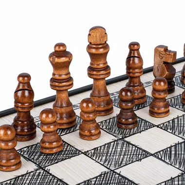 Dark wood chess pieces lined up on the sketch-design chess board