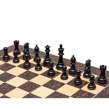 Black pieces lined up on the maple and tiger ebony chess board, diagonal view