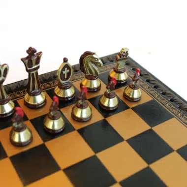 Détail des pièces d'échecs bronze et or avec le travail de peinture manuelle sur les pions centurions et la tour Colisée