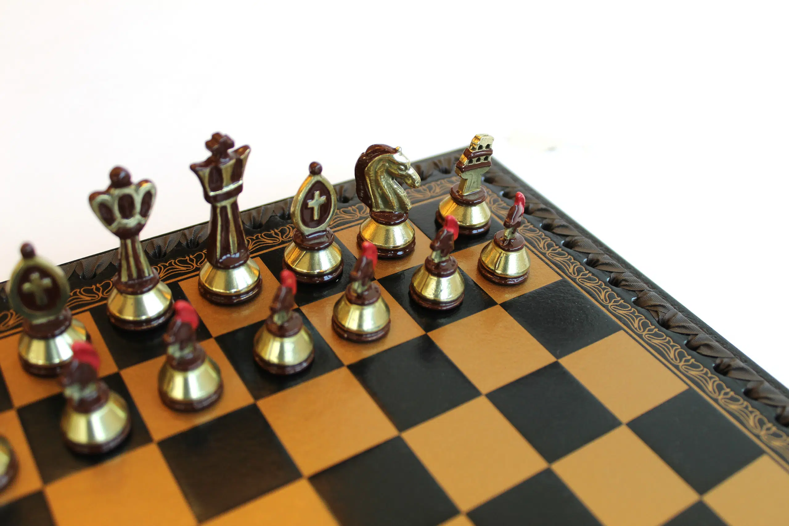 Détail des pièces d'échecs bronze et or avec le travail de peinture manuelle sur les pions centurions et la tour Colisée