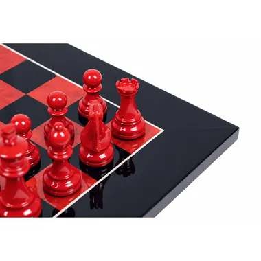 Close-up of red lacquered chess pieces and the mirror finish of the chess board