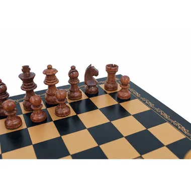 Dark acacia wood Staunton pieces lined up on the gold faux leather board